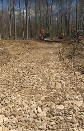 Landmark Enterprises finished gravel access road after land clearing in Dewittville, NY, with excavators on the job site